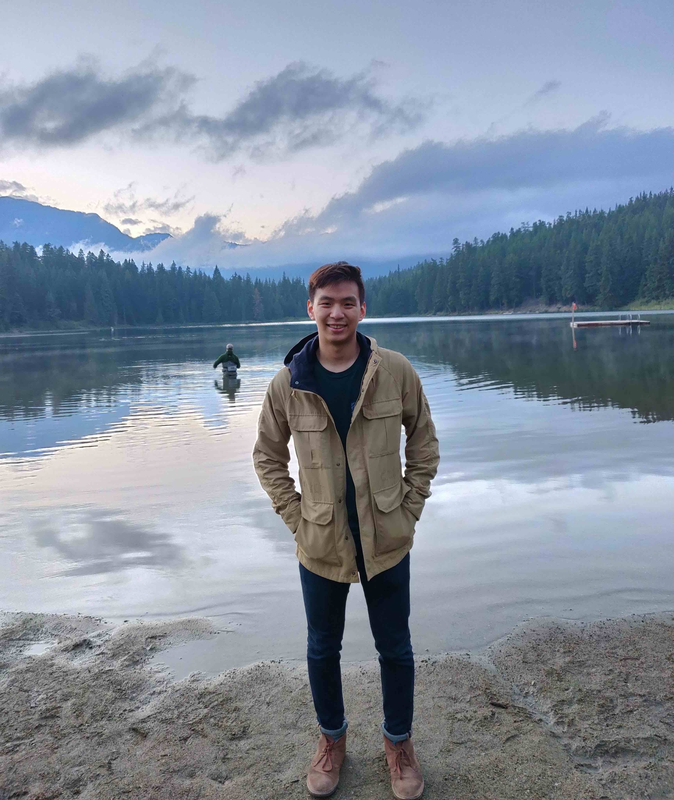 Profile image of Sam Liu standing in front of a lake, full body.