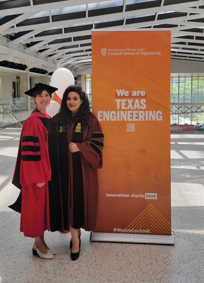 Professor Jean Anne Incorvia and Mahshid Alamdar stand in graduation gowns in front of Cockrell School of Engineering backdrop, with text reading “We are TEXAS ENGINEERING.”